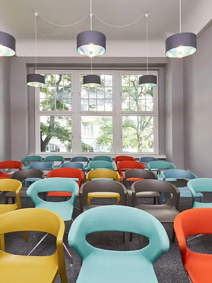 Ein Raum mit vielen bunten Stühlen.