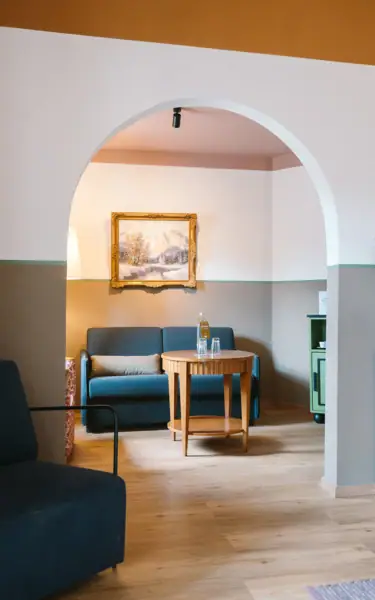 Fluss fließt an einem Gebäude und Bäumen vorbei.