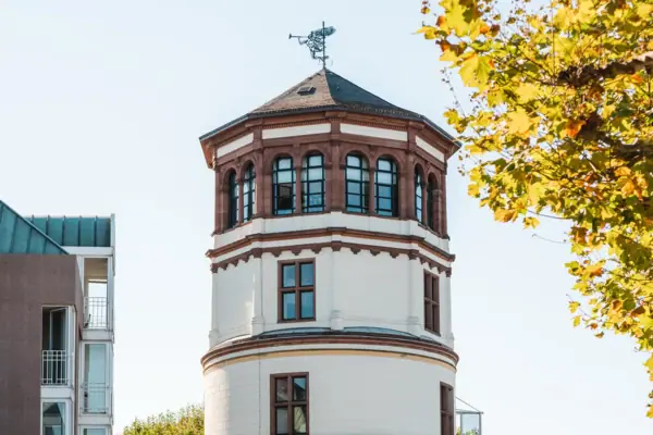 Schlossturm Düsseldorf Ein Mann fährt mit einem Fahrrad vor einem runden Gebäude.