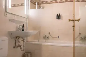 Badezimmer im Chambre mit Balkon im HENRI Garmisch-Partenkirchen Ein Badezimmer mit Waschbecken und Badewanne.
