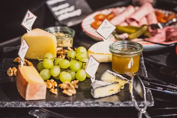 Frühstück im HENRI Hotel Wien Ein Teller mit Essen auf einem Tisch, dekoriert mit Früchten und Trauben.
