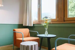 Ein Tisch und ein Stuhl in einem gemütlichen Hotelzimmer im HENRI Hotel Garmisch-Partenkirchen.