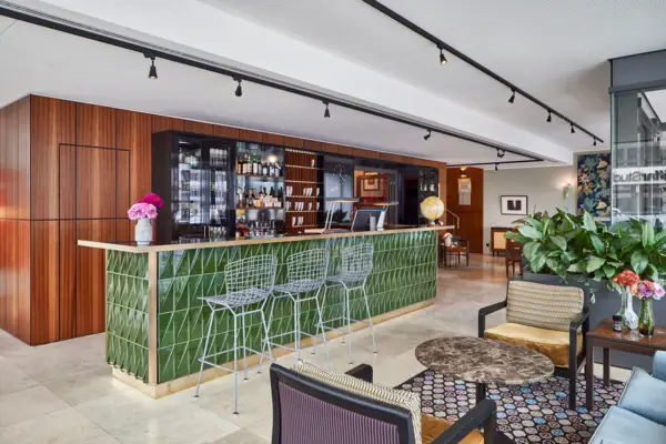 Bar mit grünen Fliesen und Stühlen.