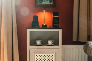 Eine Zimmerbar im HENRI Kitzbühel mit Tassen und einer Lampe darauf.