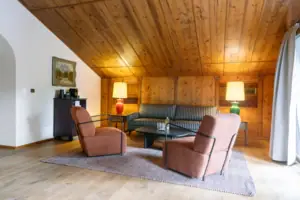 Wohnbereich im HENRI Garmisch-Partenkirchen Ein Zimmer mit einem Sofa und Stühlen.
