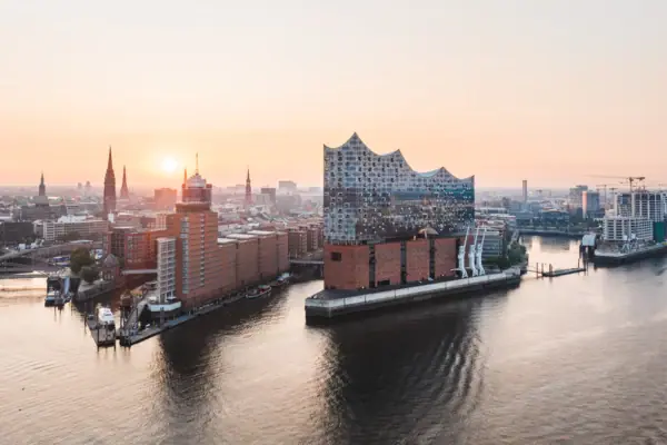 Stadtansicht von Hamburg mit Wasserfläche und Gebäuden im Sonnenuntergang.