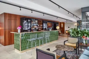 Bar mit grünen Fliesen und Stühlen.