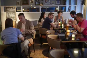 Essbereich im HENRI Hotel Hamburg Eine Gruppe von Menschen sitzt an Tischen.