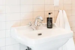 Spiegel über einem Waschbecken mit einer Blume in einer Vase