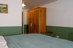 Eingangsbereich zum Salon Plus im HENRI Garmisch-Partenkirchen Hotelzimmer mit Bett und Kleiderschrank