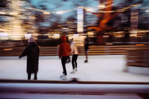 Eine Gruppe von Menschen beim Schlittschuhlaufen auf einer Eisbahn.