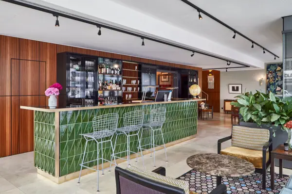 Eine Bar mit grünen Fliesen und Stühlen.