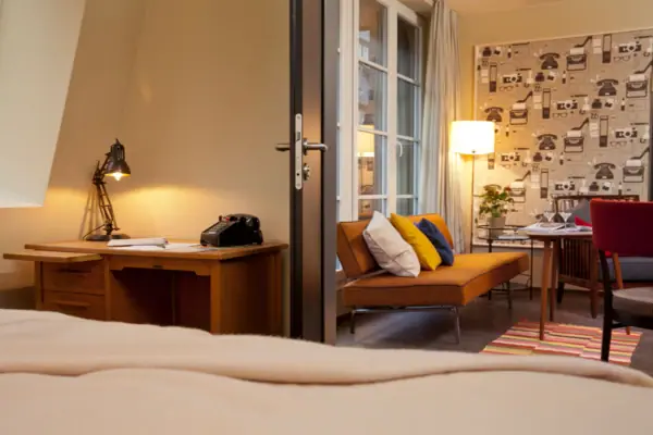 Zimmer mit Couch und Schreibtisch.