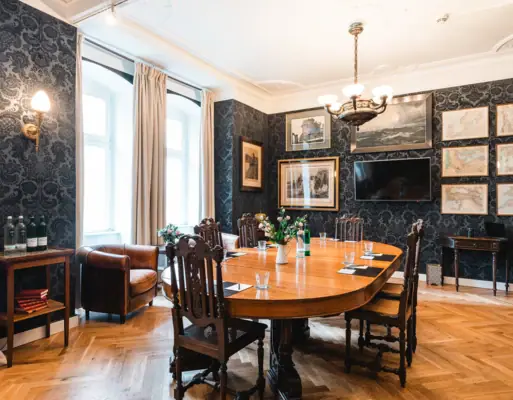 Ein Zimmer mit einem Tisch und Stühlen.