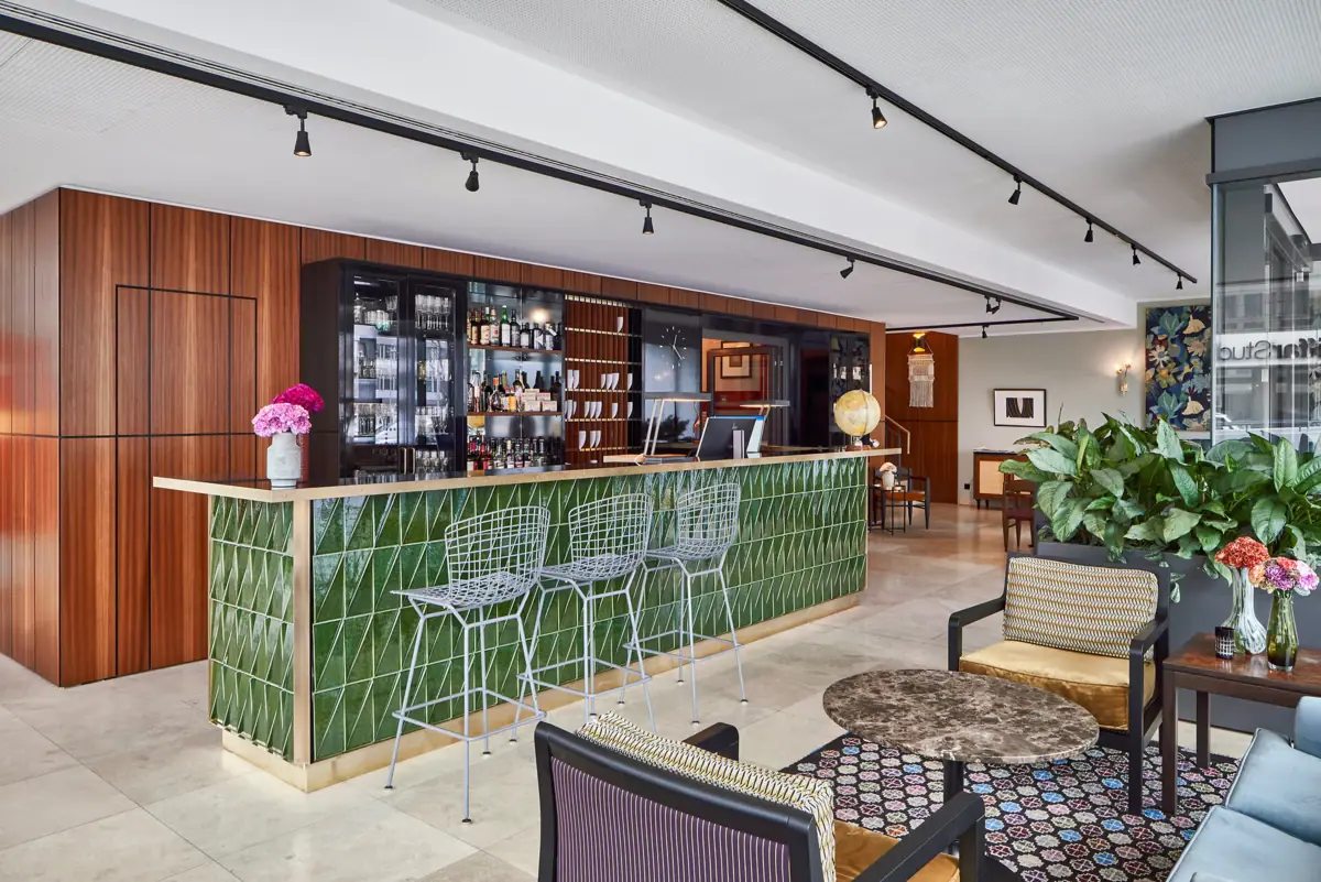 Eine Bar mit grünen Fliesen und Stühlen.