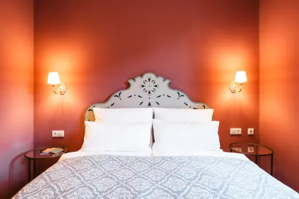 Bett mit Kissen und Wandlampe