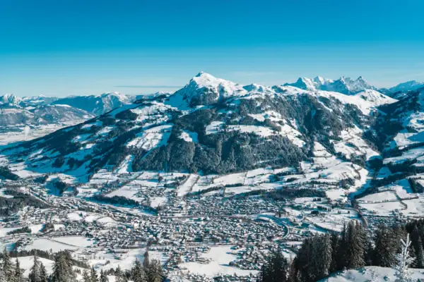 Verschneiter Berg mit einer Stadt darauf.