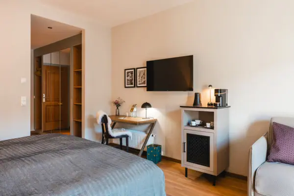 Schlafzimmer mit Bett, Schreibtisch und Fernseher