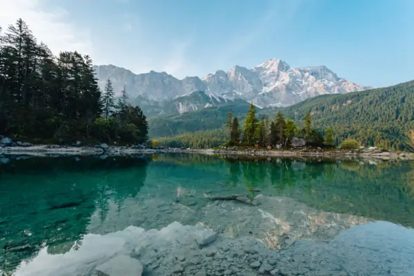 Der Eibsee mit Bäumen und Bergen im Hintergrund