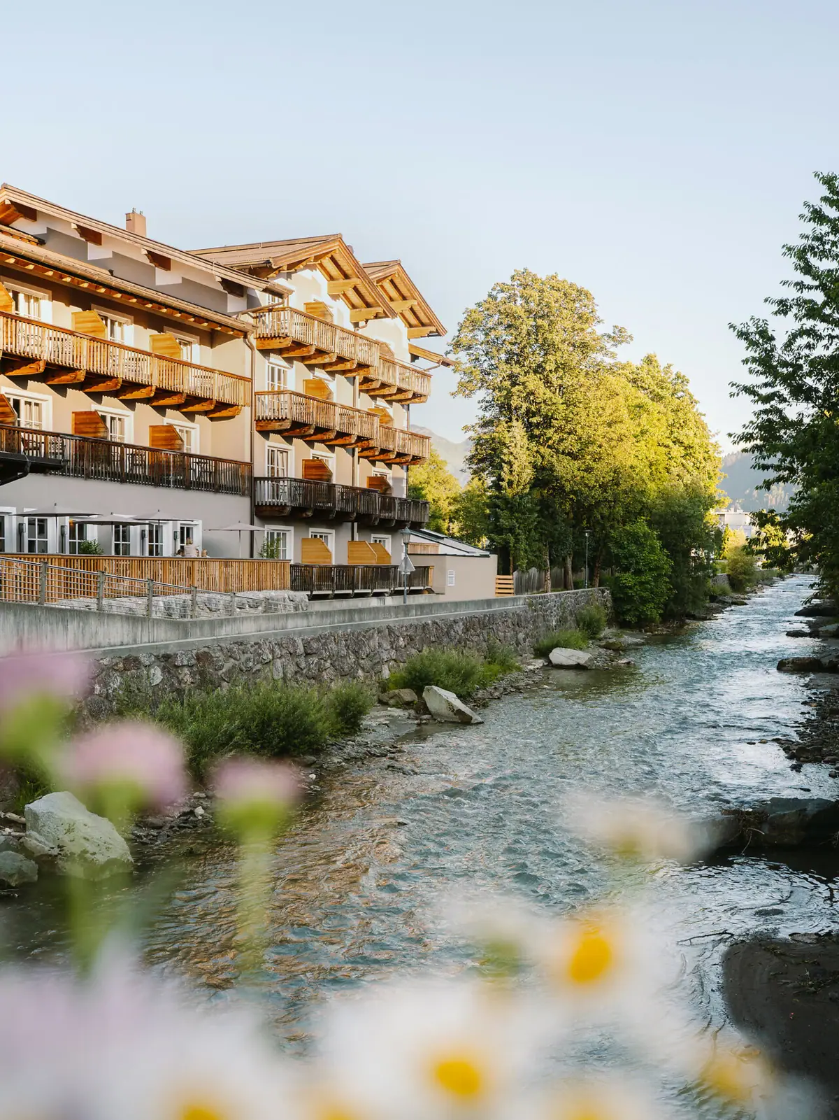 HENRI Kitzbühel Ein Hotel an einem Fluss.