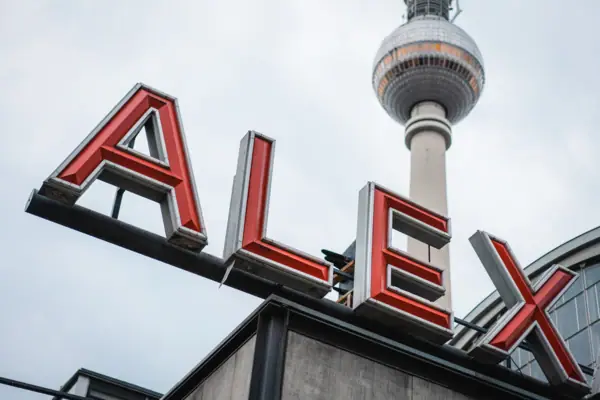 HENRI Berlin Alexanderplatz Ein Schild mit einem hohen Turm im Hintergrund.