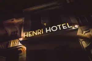 HENRI Hotel Berlin Fassade Leuchtschrift Nacht Die goldgelb leuchtende „HENRI HOTEL“ Neonschrift an der historischen Außenfassade des Hotels in Berlin bei Nacht.