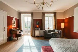 HENRI Kitzbühel Hotelzimmer Ein Zimmer mit einem Sofa und einem Schreibtisch.
