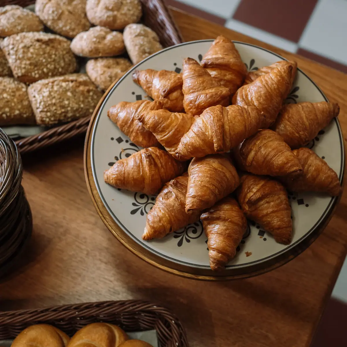 Ein Teller mit Croissants auf einem Tisch.