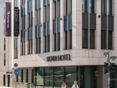 Zwischen Rheinkultur und pulsierendem Stadtleben – Düsseldorf setzt Akzente.Schon ab 55,00 € p. P. inkl. Frühstück Stadtansicht mit hohem Turm und einem Gewässer bei Sonnenuntergang.