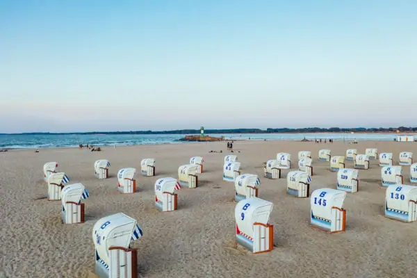 Strand Eine Gruppe von weißen und blauen Strandkörben am Strand von Travemünde.