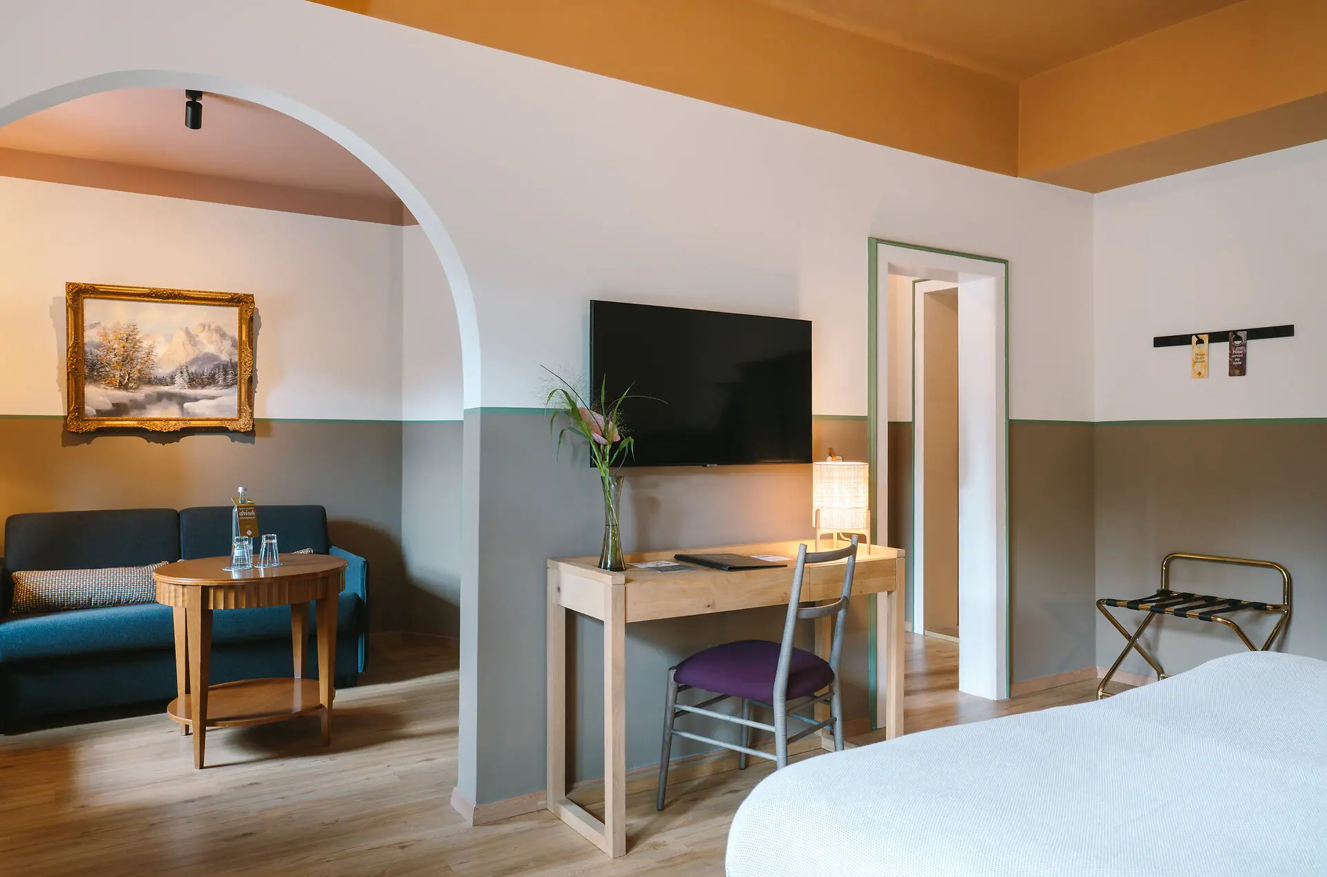 Hotelzimmer HENRI Hotel Garmisch-Partenkirchen Ein großes Hotelzimmer im HENRI Hotel Garmisch-Partenkirchen mit einem Duchgang vom Schlaf- in den Wohnbereich.