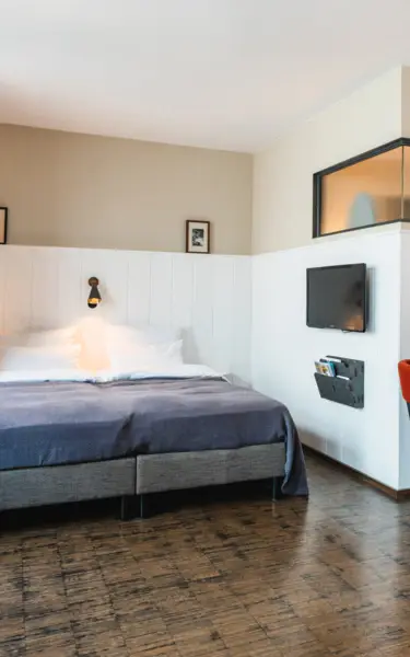 Ein Schlafzimmer mit einem Bett und einem Schreibtisch in einem Hotelzimmer.