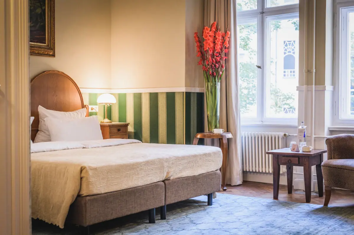 Zimmer mit Bett und Blumenvase