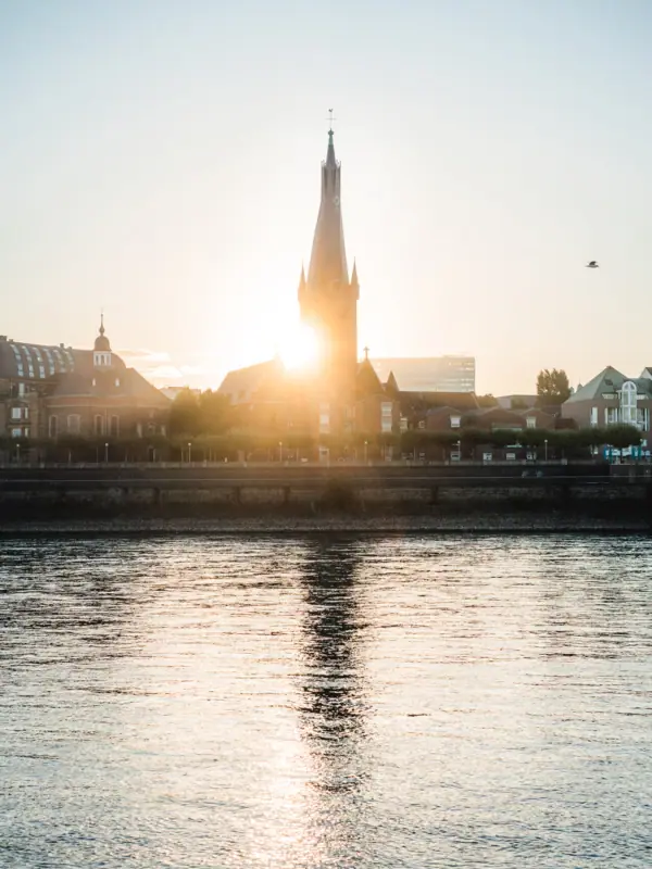 Blick auf Düsseldorf Altstadt Gebäude mit Turm im Hintergrund vor klarem Himmel.