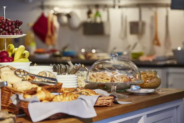 Buffet mit Brötchen, Croissants und Obst darauf.