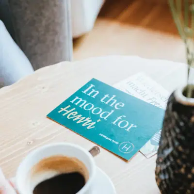 Eine Person hält eine Tasse Kaffee.