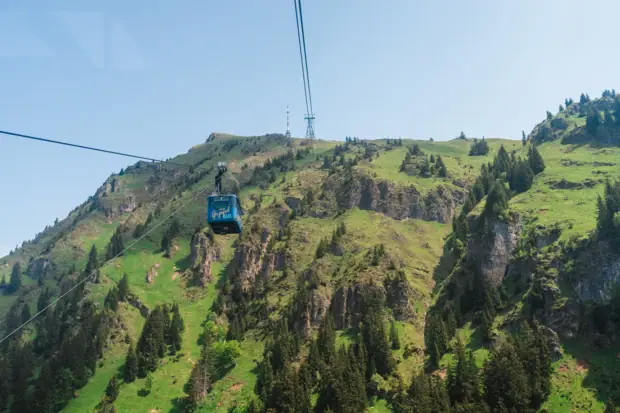 Seilbahn vor einem grünen Berghang