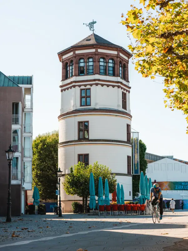 Ein Mann fährt Fahrrad vor einem runden Gebäude.