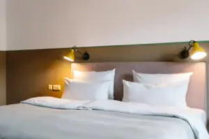 Ein Bett mit weißen Kissen und einer Lampe.