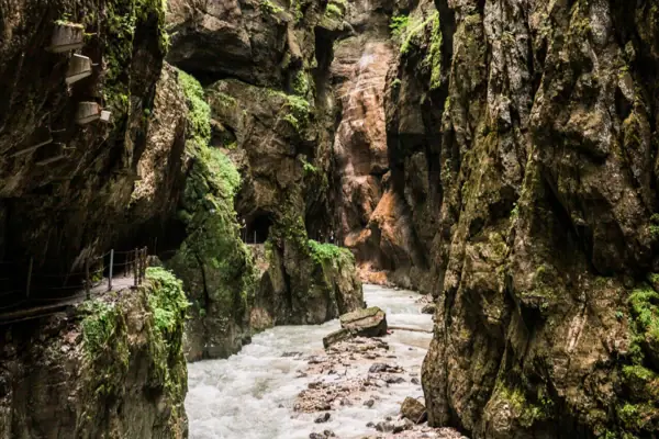 Ein Fluss fließt zwischen den Felsen der Partnachklamm hindurch.