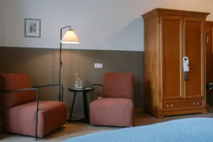 Sitzecke im Chambre mit Balkon im HENRI Garmisch-Partenkirchen Ein Zimmer mit einem Bett und Stühlen.