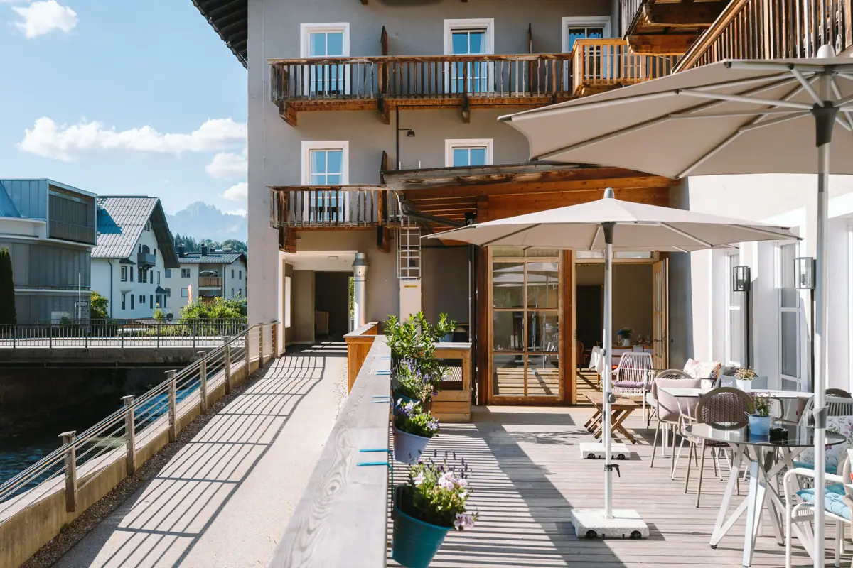 Terrasse mit Stühlen und Sonnenschirmen auf einem Deck