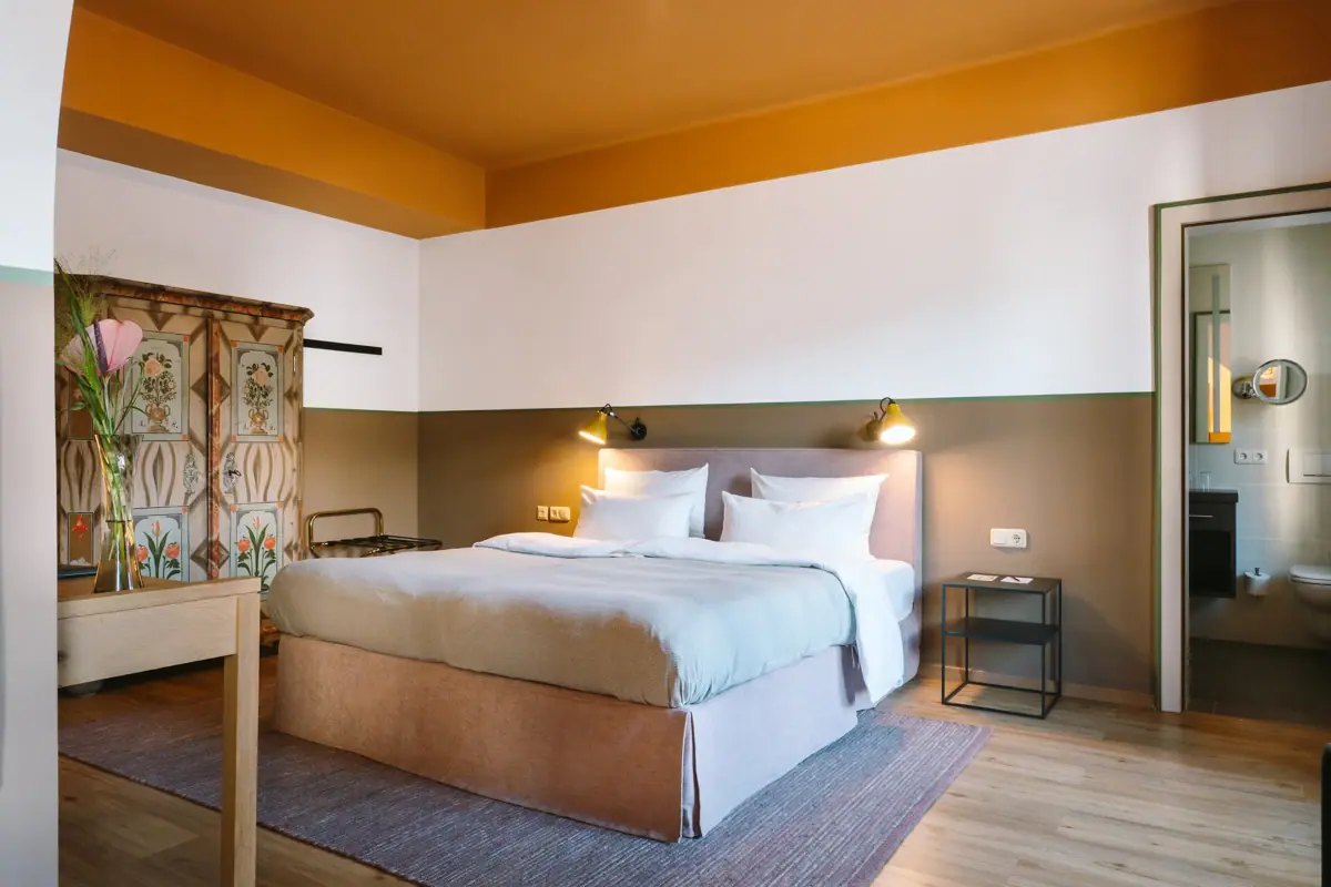 Ein Bett in einem Hotelzimmer mit stilvollem Interieurdesign.