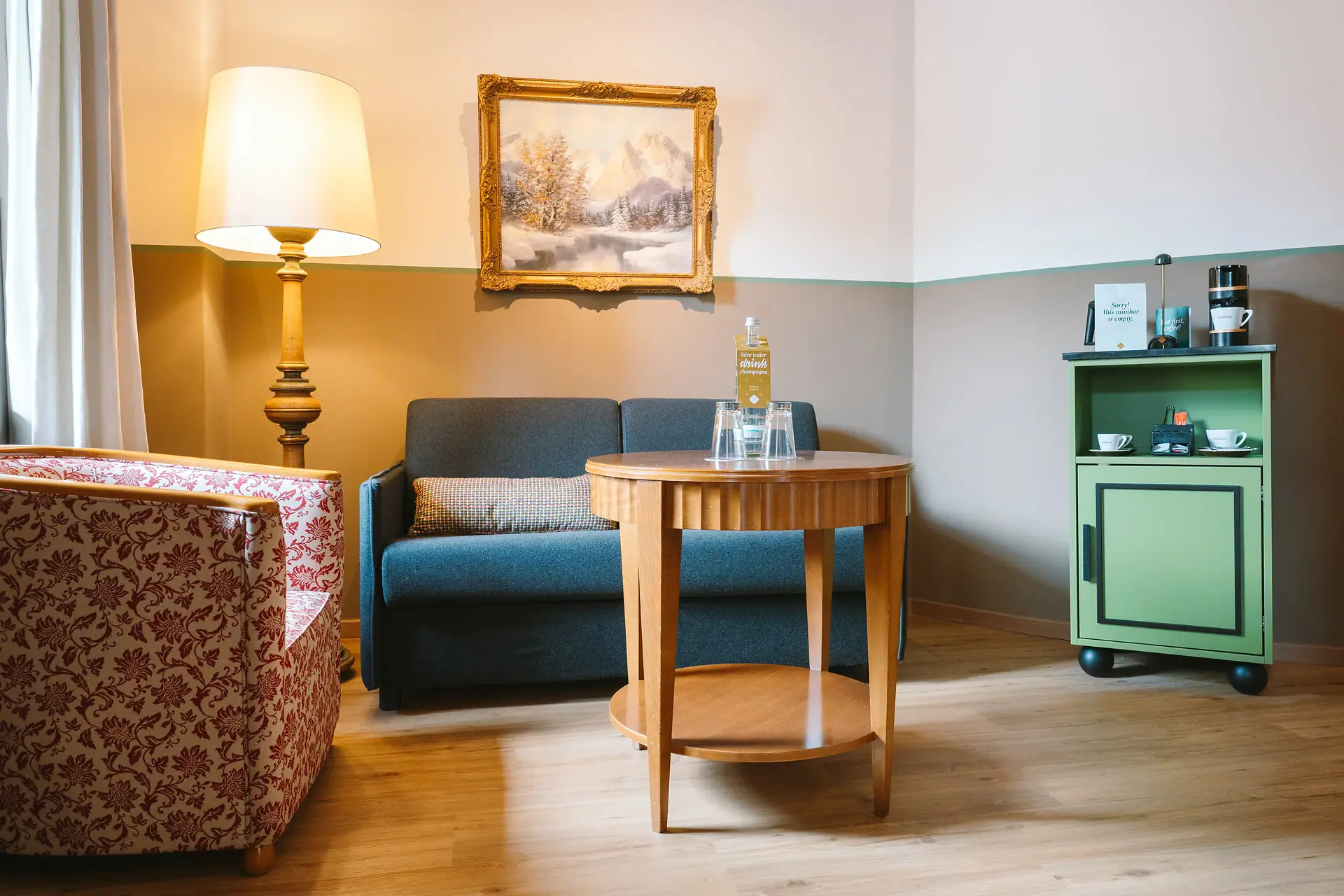 Sitzecke HENRI Hotel Garmisch-Partenkirchen mit einem Sofa und einem Tisch.