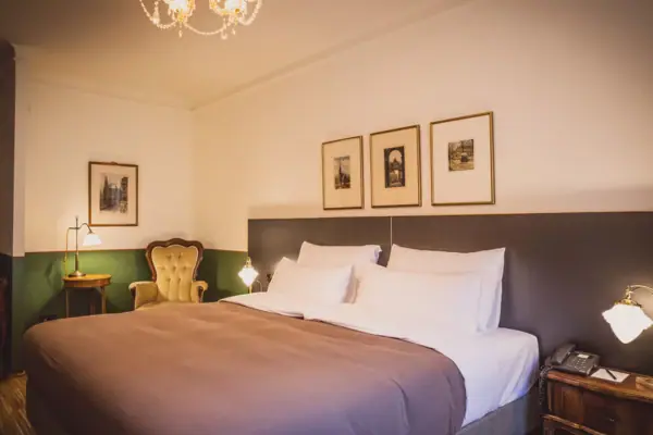 Ein Bett mit einem Kronleuchter und Bildern an der Wand.