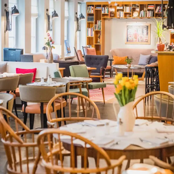 Tische, Stühle und im Hintergrund ein gemütlicher Loungebereich