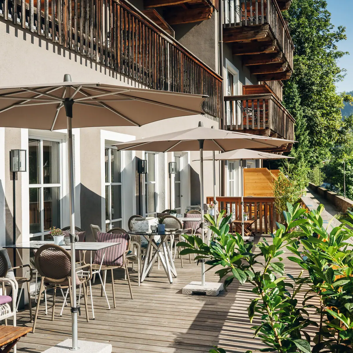 Terrasse mit Stühlen und Sonnenschirmen auf einem Deck.