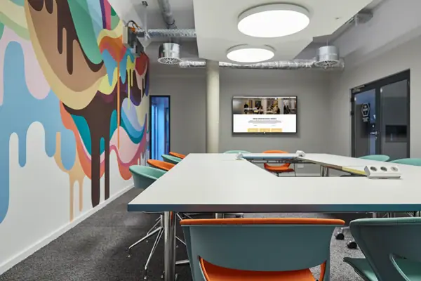 Ein Raum mit einem großen Tisch und Stühlen.