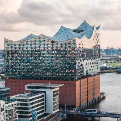 Gebäude mit großem Gewässer im Vordergrund.