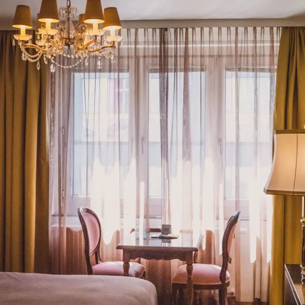 Zimmer im HENRI Hotel Wien Ein Zimmer mit einem Tisch und Stühlen.